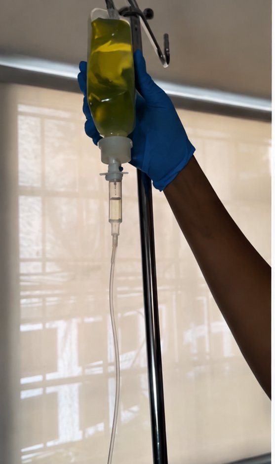 A nurse holding an IV bag on a drip stand