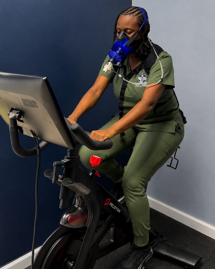 Staff member undergoing PNOE metabolic testing on an exercise bike
